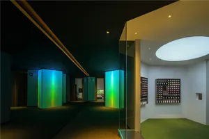 A modern spa interior with green glass walls and a circular light fixture