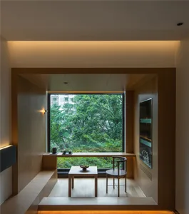 Modern living room with wooden furniture and large window overlooking greenery.