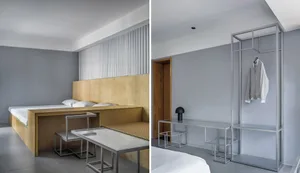 A minimalist bedroom with a metal structure, featuring a bed, desk, and integrated cabinets.