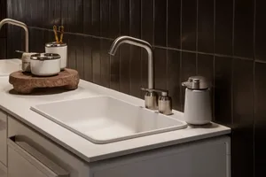 Modern bathroom with ceramic sink and metal faucet.