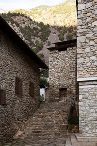 A narrow, stone staircase with a mountain in the background.
