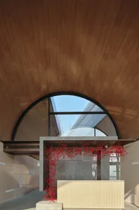 A modern lobby interior with a concrete ceiling and glass dome