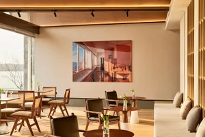 現代餐廳吧台室內，搭配木質家具、餐桌與座椅，牆面懸掛大型裱框照片。