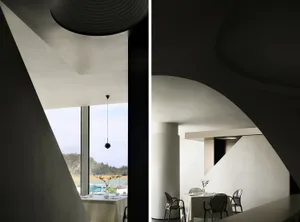 A modern restaurant interior with minimalist design and white concrete walls.