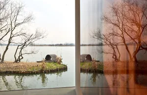A serene waterfront scene reflected in a calm lake.