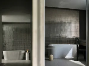 Minimalist modern bathroom featuring metallic wall tiles and a freestanding bathtub.