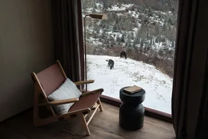 Modern interior featuring a contemporary chair with a view of a snowy landscape through a large window.