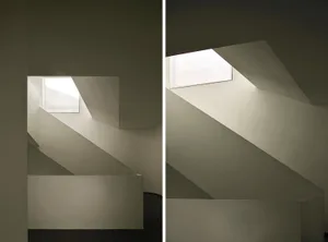 A minimalist white concrete staircase with a skylight and clean lines.