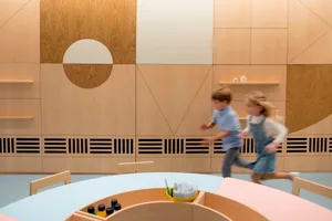 Modern playroom with wooden elements, children playing.