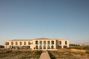 A modern style exterior of a hotel building made of sandstone material.