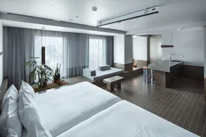 Modern hotel room with concrete tiles, plants, and minimalist design