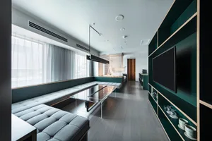 Modern living room featuring a clear glass table, contemporary furniture, and minimalist decor.