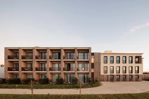 Modern residential building with wooden panels, concrete accents, and glass balconies.