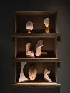 Modern sculptures crafted from wood displayed on a shelf.