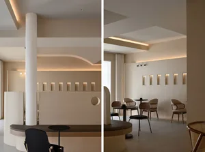 Photograph of a modern coffee shop featuring neutral-toned tiles, panels, and walls.