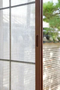 A close-up of a traditional window with a wooden frame, showcasing the texture and craftsmanship.