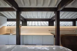 Interior space featuring white wood beams and concrete surfaces.