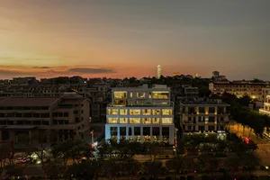 Cityscape with illuminated buildings against a sunset sky