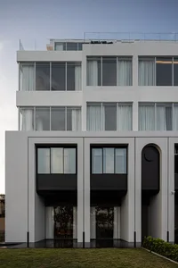 Modern building with concrete facade and large windows.