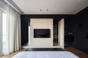 White tiled bedroom floor with minimalist decor and a television