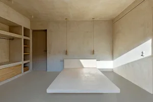 Modern minimalist bedroom with concrete furniture and walls