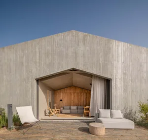 Modern, minimalist house with concrete exterior and an open space.