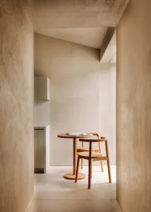 A minimalist workspace featuring wooden furniture and a white table.