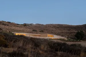 現代極簡住宅，外觀為混凝土，地下洞穴有燈光照明