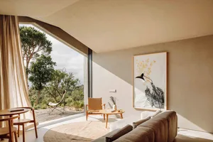Modern living room with minimalist design featuring neutral tones, natural light, and a blend of organic and geometric shapes