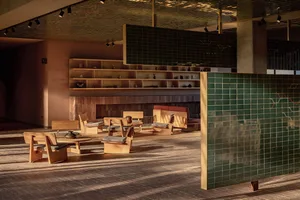 An industrial-style lobby featuring brick flooring, wooden furniture, and ceramic tiles.