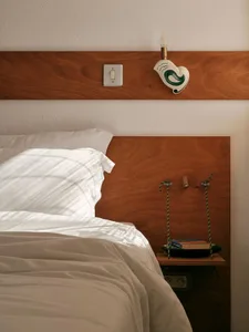 A minimalist bedroom with a wooden headboard.