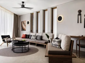 A minimalist living room with modern interior design, featuring wooden furniture, concrete accents, and leather upholstery.