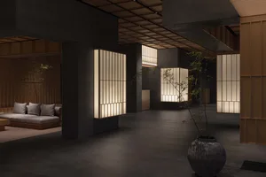 A minimalist lobby with concrete walls, square lightboxes, and a potted plant