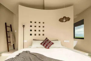 Bedroom with minimalist design, neutral colors, and neutral-colored bedding.