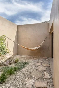 A minimalist residential patio featuring concrete and stone surfaces.