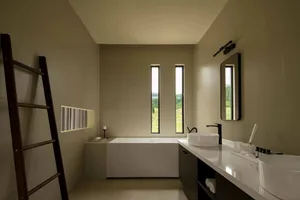 Modern bathroom with natural light, concrete tile, and minimalist design.