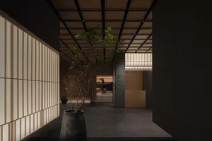 Modern hotel entryway featuring a concrete wall and wooden flooring.