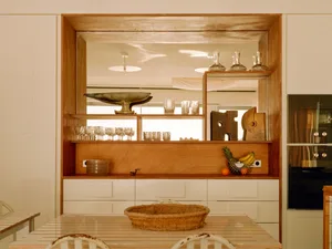 Modern kitchen featuring a wooden storage unit with glass shelves.