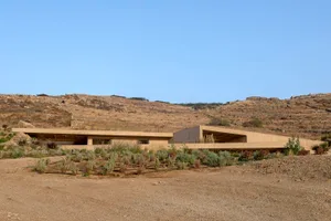 A modern residential building constructed entirely from concrete, featuring clean lines and minimalist design.