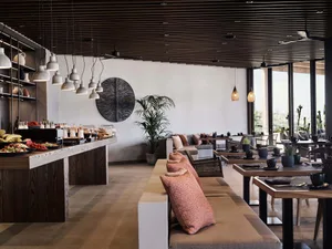 Modern restaurant interior with wooden furniture, metal accents, and ceramic elements.