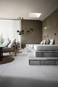 Interior design image featuring a modern, industrial relaxation space with concrete and stone materials.