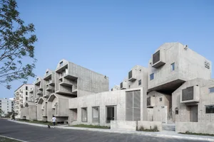 Modern residential buildings with concrete exterior and large windows.