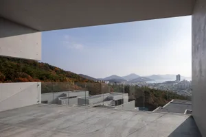 View from a modern building showcasing concrete materials and a scenic landscape.