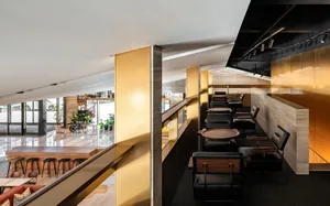 Modern cafe design featuring metallic finishes and wooden furniture.