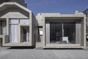 A modern cement building exterior with large glass windows and a concrete facade.