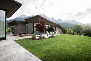 A modern house with large glass windows and a sloped roof designed for energy efficiency and minimalism.