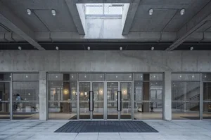 Modern industrial-style lobby featuring concrete and glass materials.