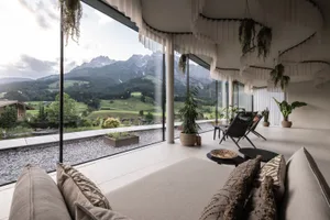 Modern living room with concrete and glass features, showcasing contemporary design.