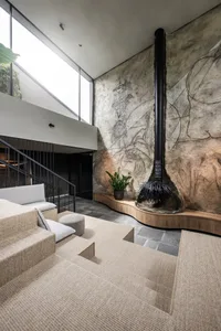 Modern living room featuring a concrete wall with abstract drawings and a wooden floor with steps.