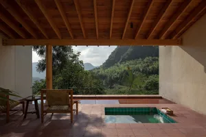 A modern minimalist patio featuring a swimming pool surrounded by a tiled floor and wooden beams.
